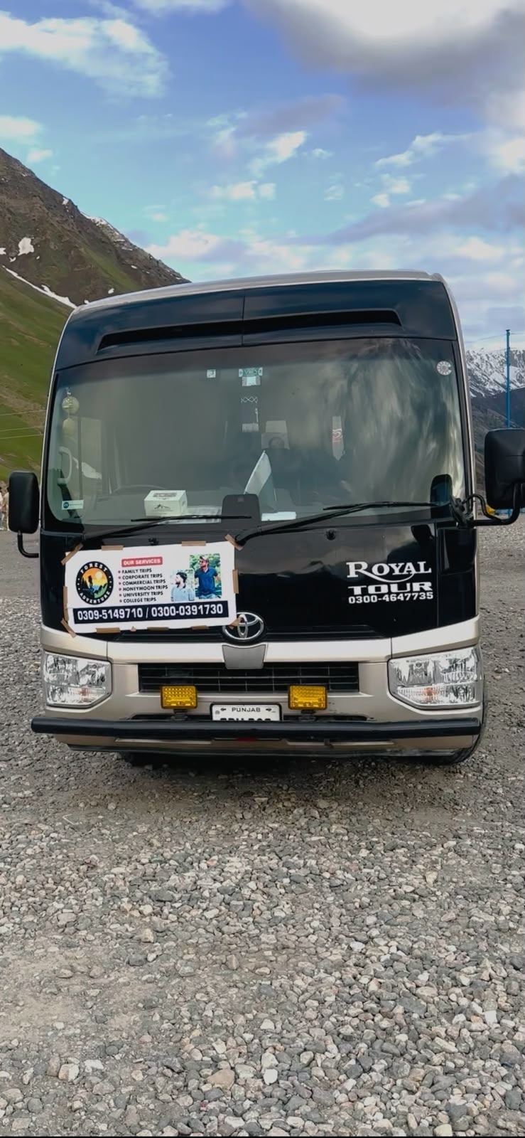 Toyota Coaster tour bus parked in the mountains