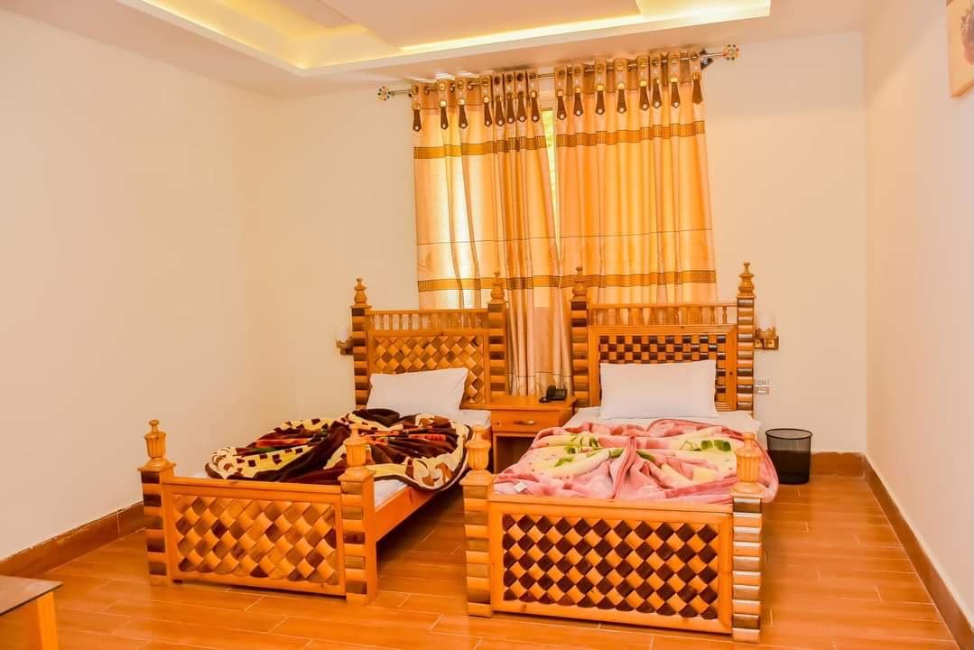 Twin bed hotel room with wooden furniture